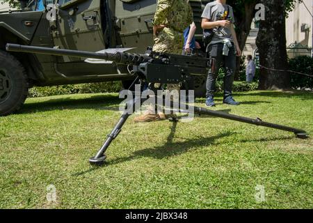 The M2 machine gun or Browning .50 caliber machine gun placed on urban zone. Effective against infantry, unarmored or lightly armored vehicles and aircrafts. Stock Photo