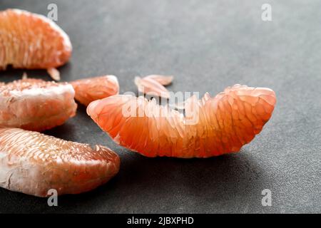 Pomelo Fruit on Dark Background, fresh pomelo peeled on pomelo skin and green leaf frome pomelo tree, pummelo, grapefruit in summer tropical fruit in Stock Photo