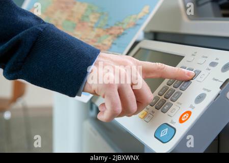 Closeup of a man's hand using a printer in office. Stock Photo