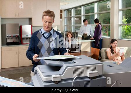 Man making copies of a map in breakroom at office Stock Photo
