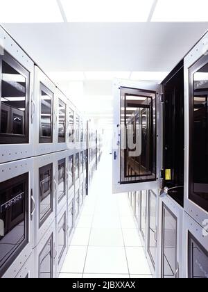 Large empty server room with one cabinet open in foreground Stock Photo