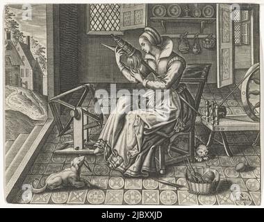 A woman in an interior near a spinning wheel and a basket of full spools. Under her chair sits a cat, at her feet lies a dog. On the left, a view through to some houses., Spinner in an interior, print maker: Jan van Halbeeck, (mentioned on object), Paris, 1600 - 1630, paper, engraving, etching, h 106 mm × w 134 mm Stock Photo