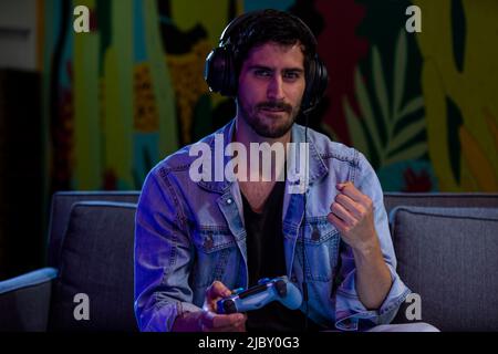 Excited man pumping his fist up while playing video games. Stock Photo