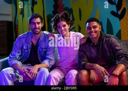 Young group of friends smiling at camera in a modern hipster room. Stock Photo