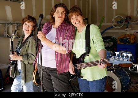 Portrait of Garage band composed of middle aged women with instruments, practicing in residential garage Stock Photo
