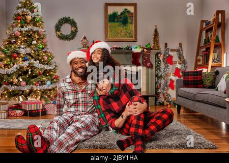 Multi racial family gathered in living room celebrating Christmas. Stock Photo