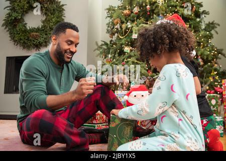 Young single father celebrating Christmas with his two children Stock Photo