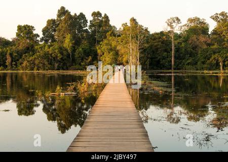 The boardwalk crossing the pool at sunset from Neak Poan in the Angkor complex Stock Photo