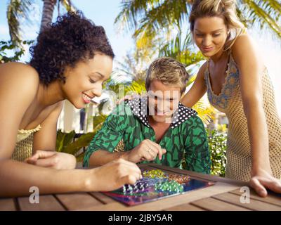 Young adults playing board game on outside table and smiling Stock Photo