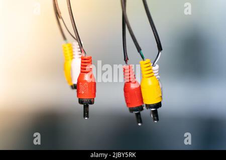 Multicolored connector plug tulip close up. Old RCA connector on a blurred background. Worn audio connection wires Stock Photo