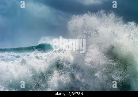 Huge wave curling over and breaking during cyclone Ola with stormy sky Stock Photo