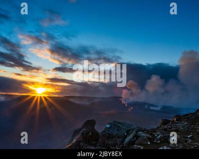 Clouds at sunset and glowing river of lava, Fagradalsfjall Volcanic eruption at sunset, Iceland Stock Photo