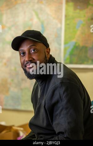 Portrait of middle aged bearded black man wearing a baseball hat looking towards camera Stock Photo