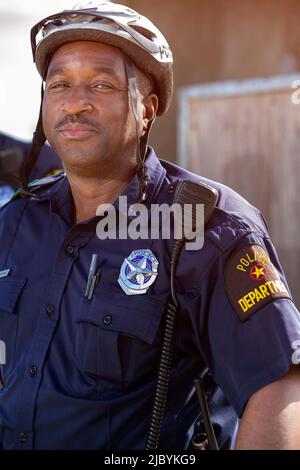 Portrait of Bicycle Police officer standing outside looking towards camera smiling Stock Photo