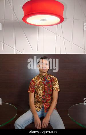 Serious Malaysian man sitting in cafe Stock Photo