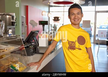 Malaysian man working in cafe Stock Photo