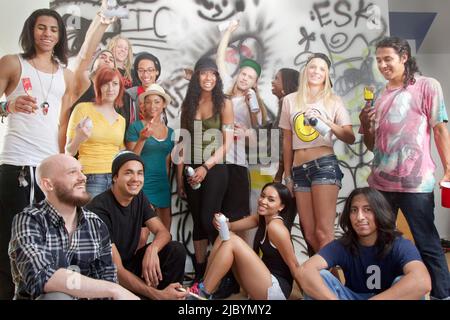 Friends hanging out together in graffitied room Stock Photo