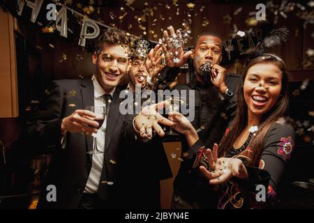 Friends drinking in kitchen at New Year's Eve party Stock Photo