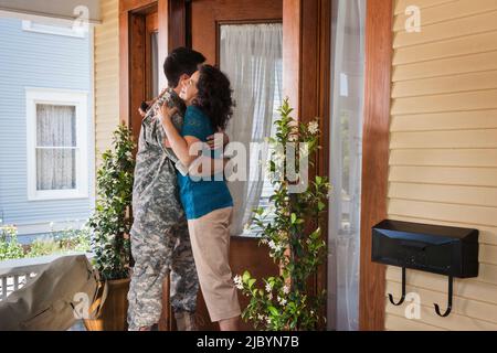 Hispanic mother greeting soldier son Stock Photo