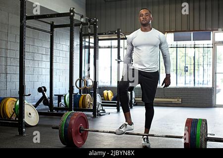 Black athlete standing at barbell in gym Stock Photo