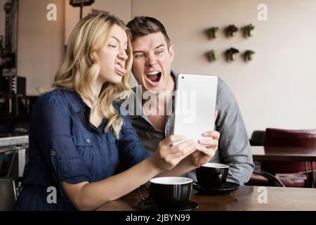 Caucasian couple using digital tablet together Stock Photo