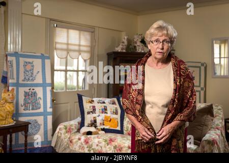 Cat lady standing in decorated living room Stock Photo