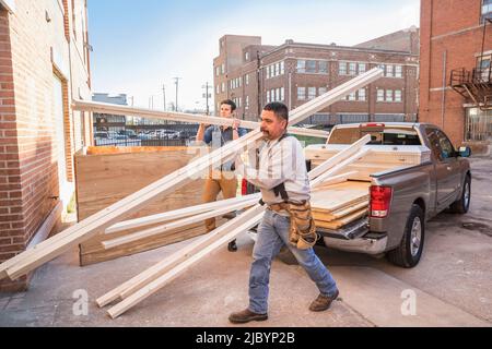 Workers carrying wood at construction site Stock Photo