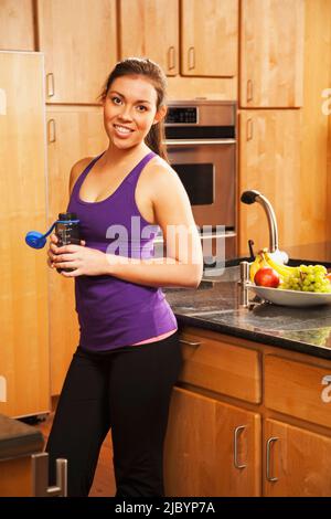 Hispanic woman drinking water after exercise Stock Photo