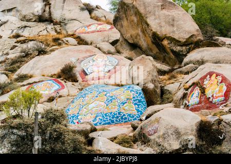 Tibetan Buddhist paintings on mani stones (om mani padme hum) in the Drepung Monastery of the at the foot of mount Gephel in Lhasa, Tibet. Stock Photo