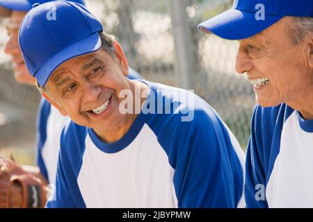 Senior Hispanic men playing on baseball team Stock Photo