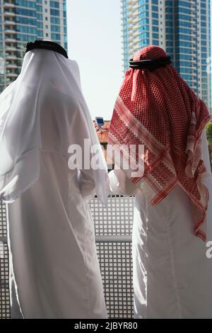 Middle Eastern man in traditional clothing looking at highrise Stock Photo