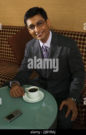Indian businessman drinking coffee in cafe Stock Photo