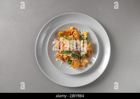 Pasta pappardelle with beef ragout sauce in grey bowl. Grey background Stock Photo