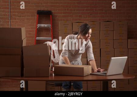 Hispanic woman typing on laptop Stock Photo