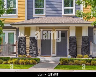 Entrance of a low-rise townhouse with a patio in Vancouver, Canada. Home exterior with patio area with nice landscaping desing around. Nobody, selecti Stock Photo