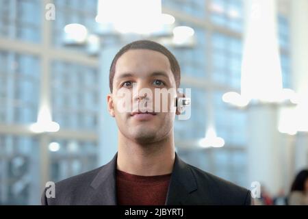Hispanic businessman wearing hands-free cellular device Stock Photo