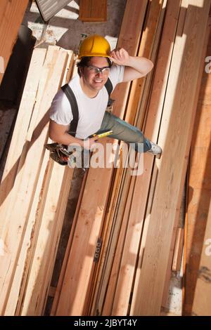 Mixed race construction worker standing on lumber Stock Photo