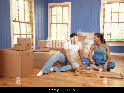 Couple eating pizza in new house Stock Photo
