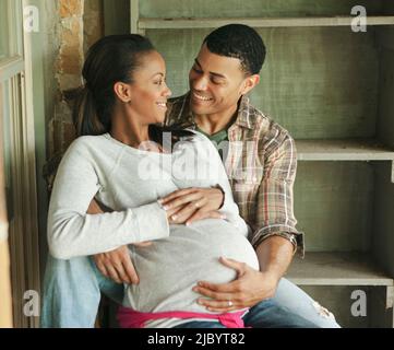 Husband hugging pregnant wife's stomach Stock Photo