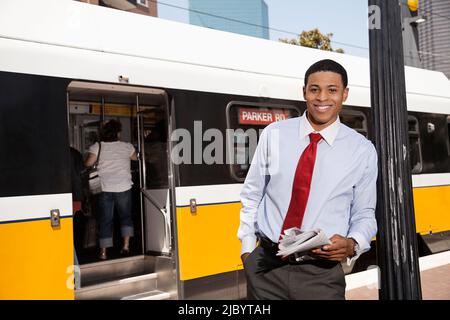Businessman reading newspaper on city street Stock Photo