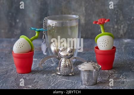 Tea brewing tools in the form of frogs and flowers with glass of tea. Stock Photo