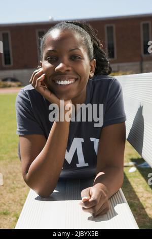 African American woman laying on bench Stock Photo