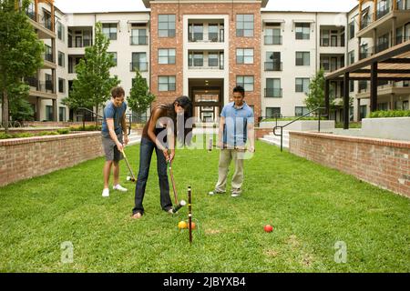 People playing croquet on lawn Stock Photo