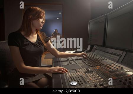 Caucasian woman working at audio control panel Stock Photo