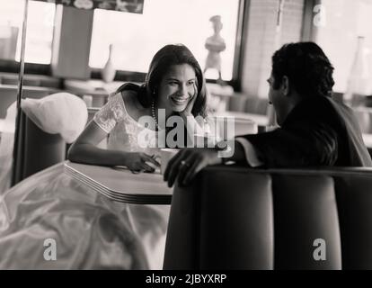 Bride and groom eating at diner Stock Photo