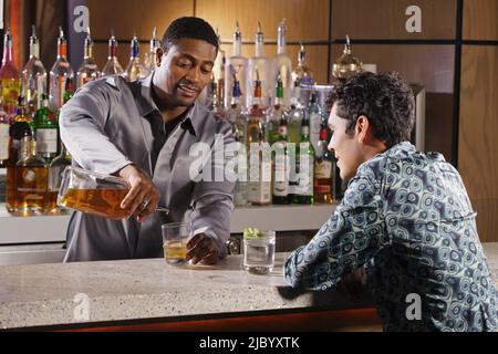 African man bartender pouring drink Stock Photo