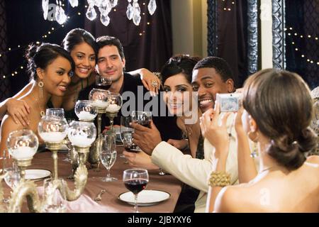 Multi-ethnic friends having photograph taken at dinner party Stock Photo