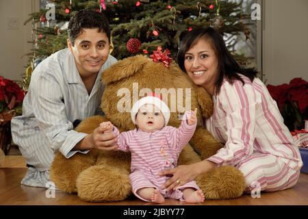 Hispanic parents and baby on Christmas Stock Photo
