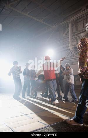 Multi-ethnic break-dancers in warehouse Stock Photo