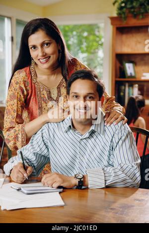 Indian couple paying bills at table Stock Photo